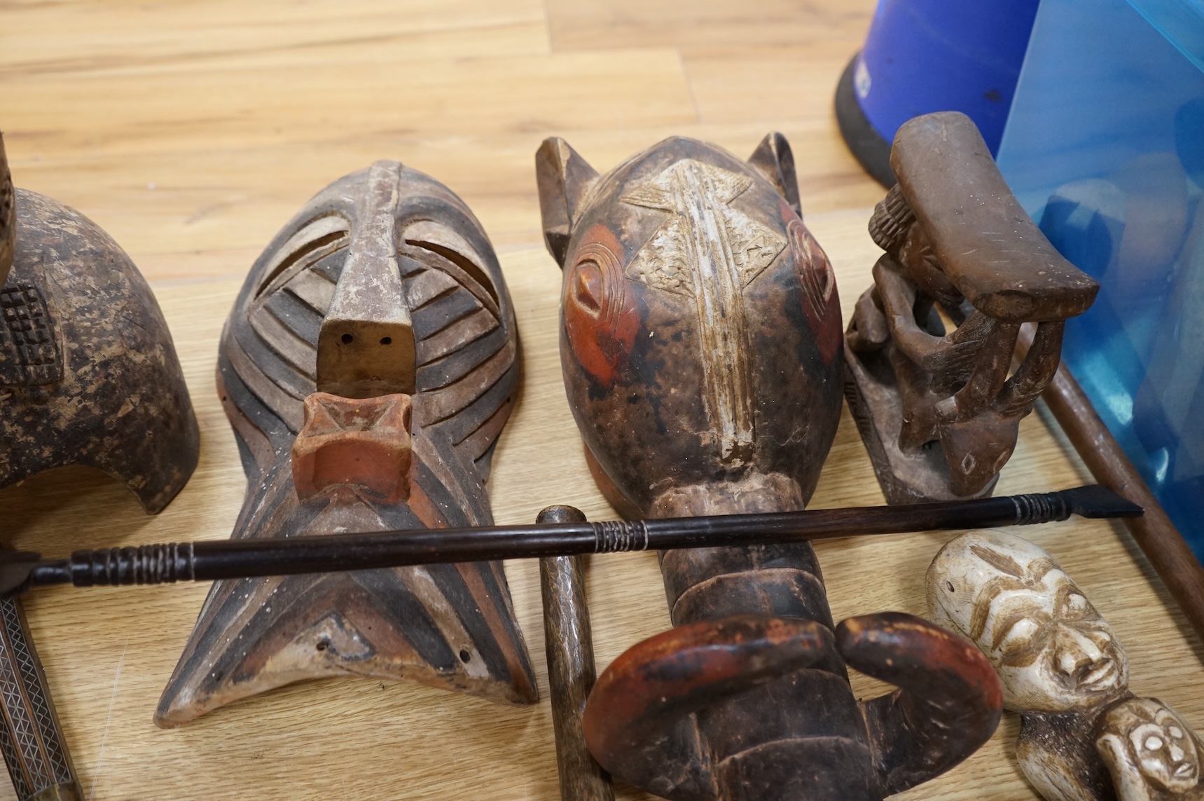 An eclectic group of tribal carvings to include a stool, various weapons, masks, etc, largest mask 52cm high